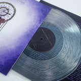 A clear marbled vinyl record from Hold Close is partially out of its purple and white cover with a dreamcatcher design. The label shows album "Time" plus track info, with Cloud9 and Tropical Depression visible.