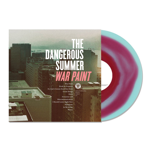 A limited edition electric blue and red swirl vinyl by The Dangerous Summer is partially pulled from its cover, which displays city buildings at sunset along with the album title 