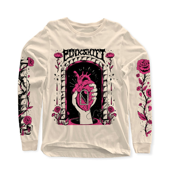 image of a natural, tan colored long sleeve tee on a white background. tee has a full body chest print that says pinkshift at the top in black, with an image below of a hand holding a human heart. inside the heart is a doorway, with stairs. surrounding the hand are pink flowers. both sleeves have prints with pink flowers