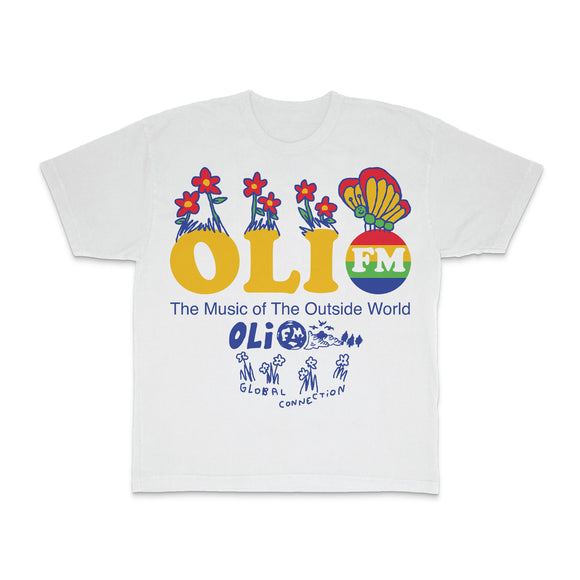 White t-shirt on a white background. Chest print shows OLI in yellow text with FM in a multi-color circle. Flowers and Butterflies come out of the lettering. The Music of the Outside World text below in blue above blue text Global Connection