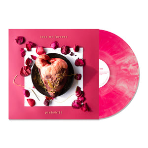 Vinyl Album cover for Pinkshift "Love Me Foreverr" on a white background. Album cover has a square pink background. In the middle is a heart on a black plate surrounded by rose petals. Vinyl color is Pink Galaxy